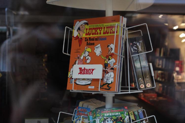 Ein Lucky Luke Comic in einem Regal mit der Aufschrift „Asterix“.